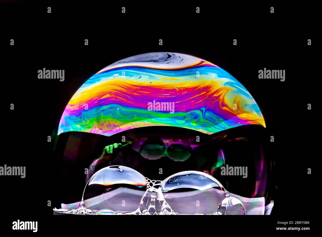 Gros plan Kaléidoscope de bulles colorées tourbillonnantes photographiées en studio avec un fond noir Banque D'Images