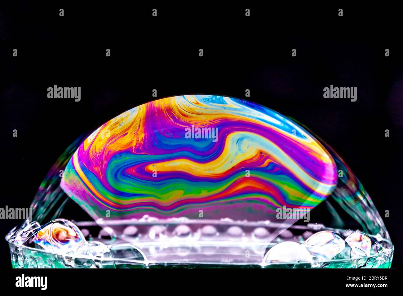 Gros plan Kaléidoscope de bulles colorées tourbillonnantes photographiées en studio avec un fond noir Banque D'Images