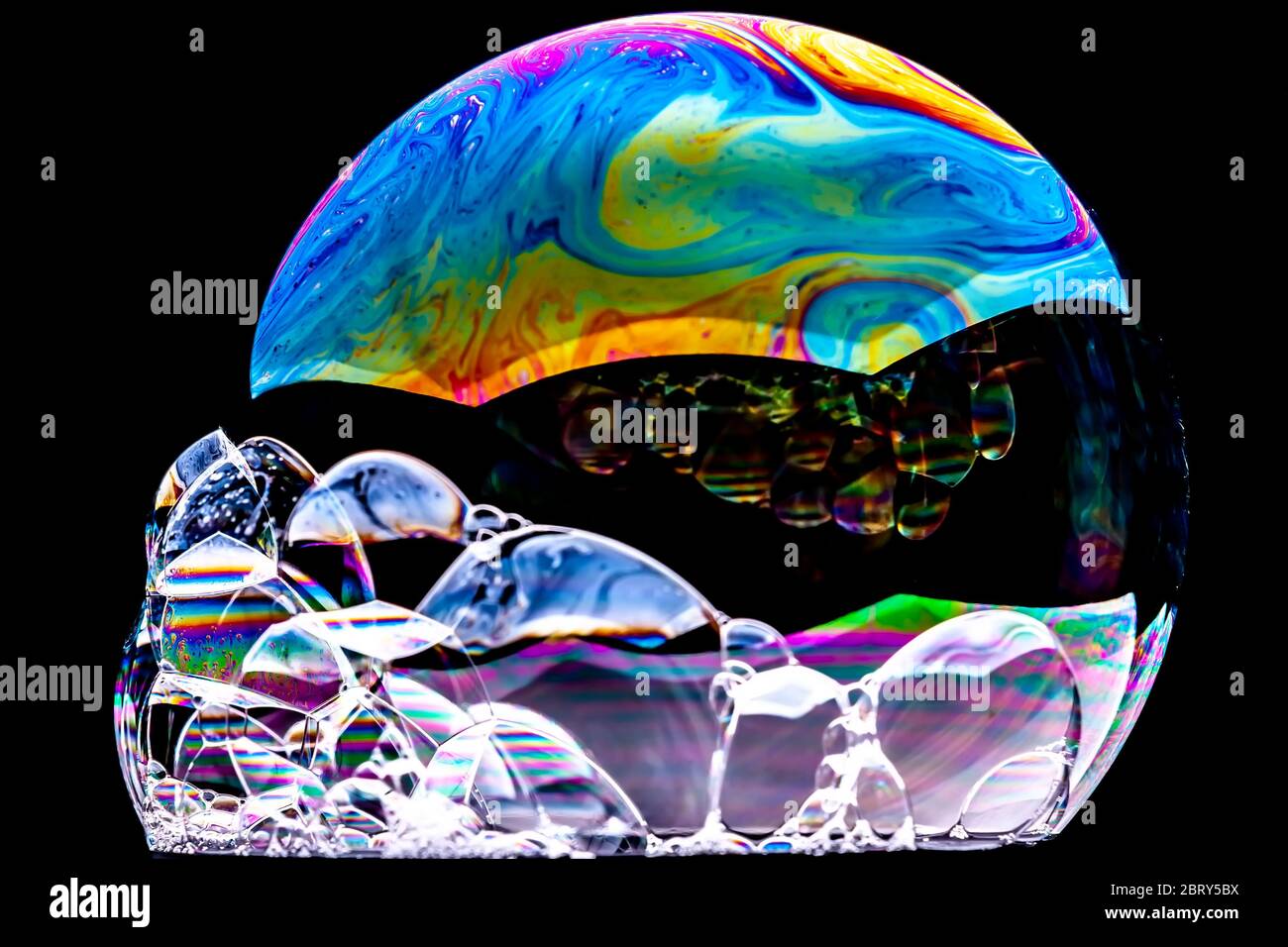 Gros plan Kaléidoscope de bulles colorées tourbillonnantes photographiées en studio avec un fond noir Banque D'Images