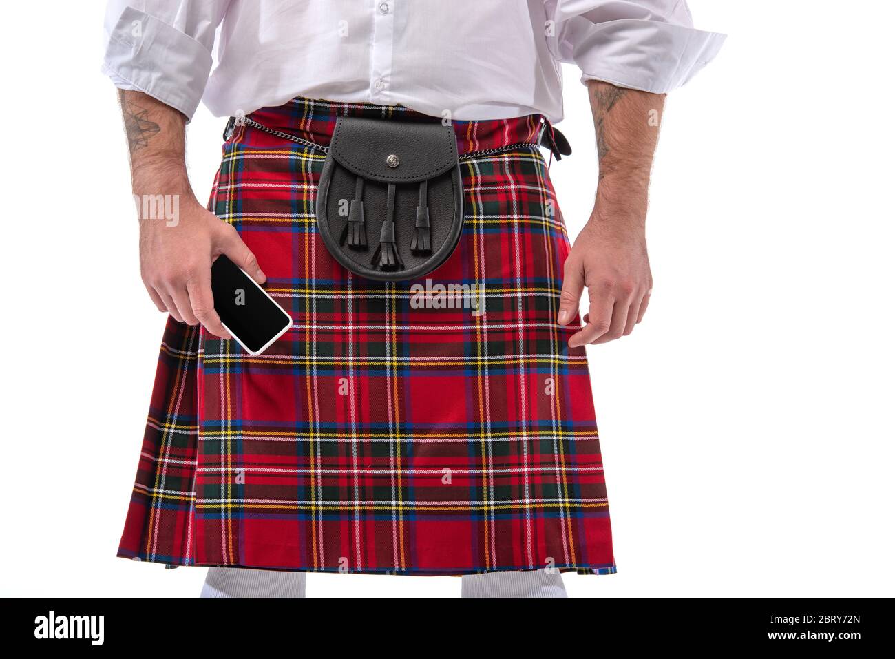 Vue rognée de l'écossais dans un kilt rouge avec sac de ceinture en cuir et  smartphone isolé sur blanc Photo Stock - Alamy