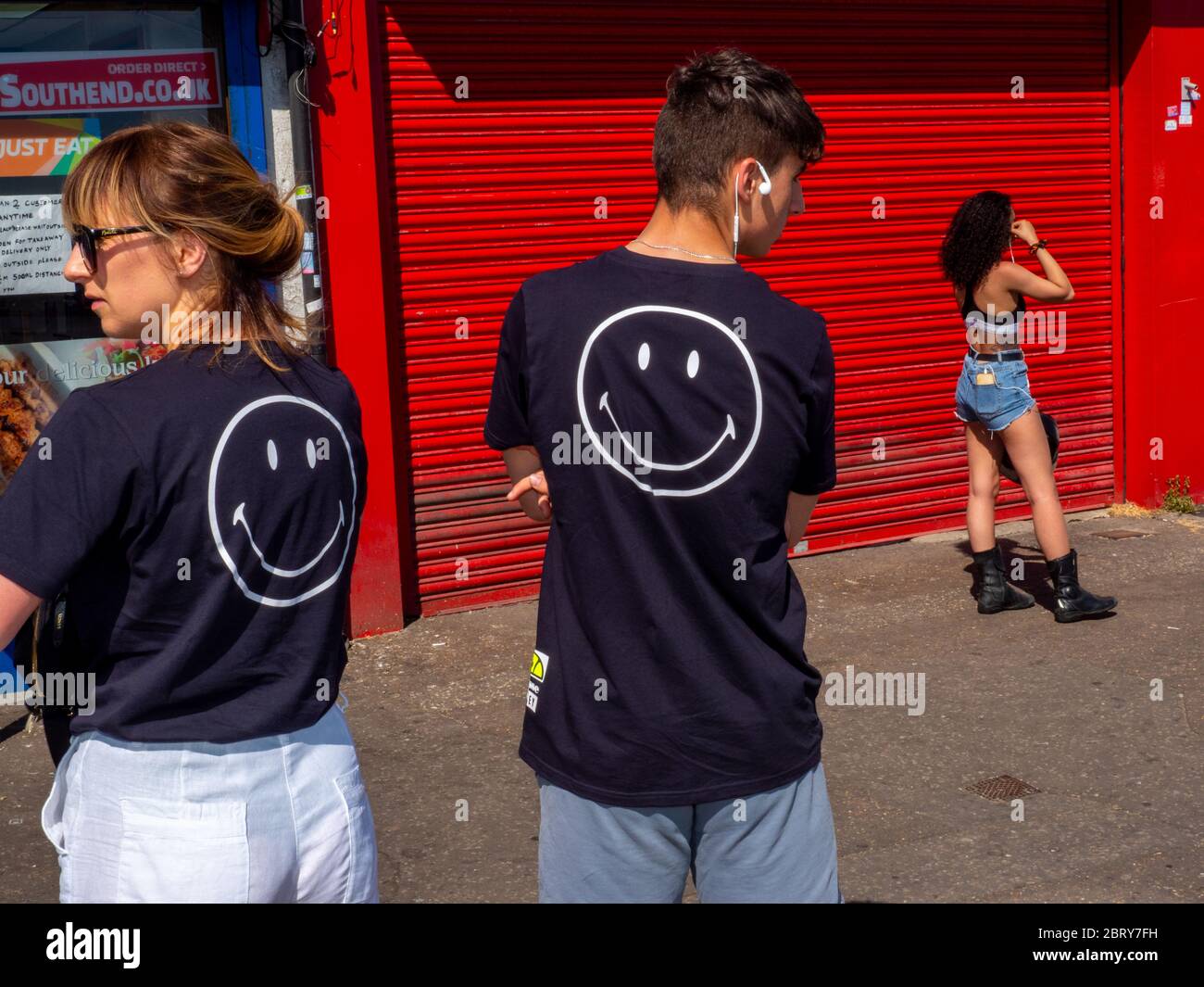 Un homme dans un smiley visage t-shirt queeus pour un déleater à Southend. Banque D'Images