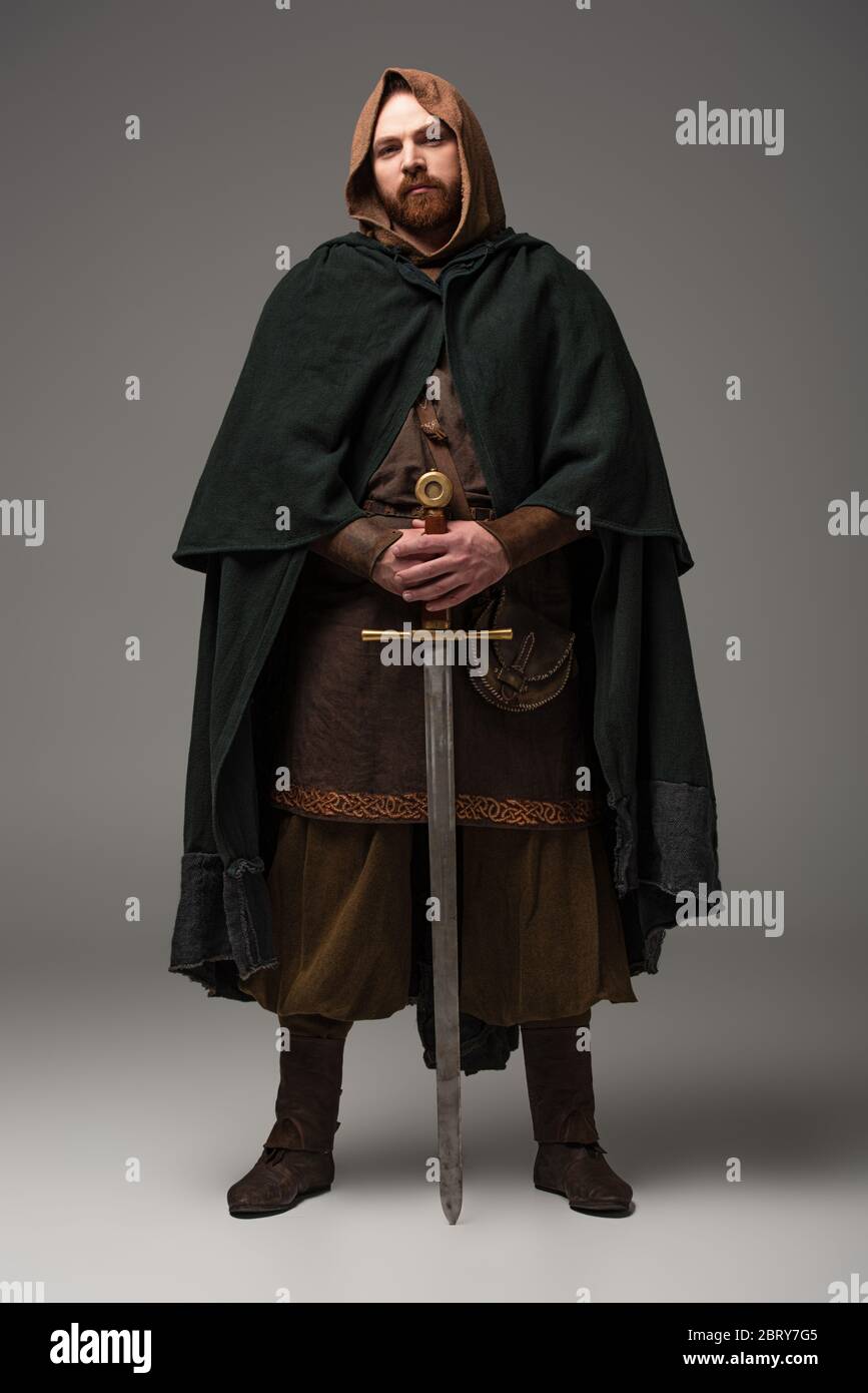 Chevalier rouge écossais médiéval en manteau avec épée sur fond gris Photo  Stock - Alamy