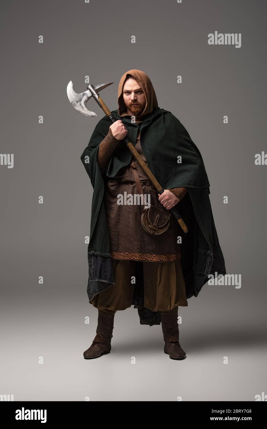 Homme écossais médiéval à tête rouge dans un manteau avec hache de bataille  sur fond gris Photo Stock - Alamy