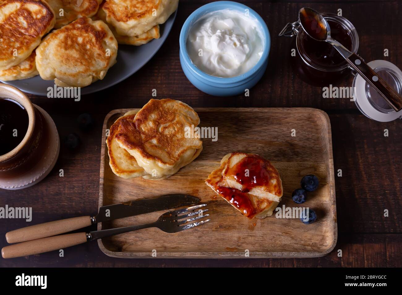 Beignets à la crème aigre, confiture et bleuets. Le plat traditionnel russe. Gros plan. Banque D'Images