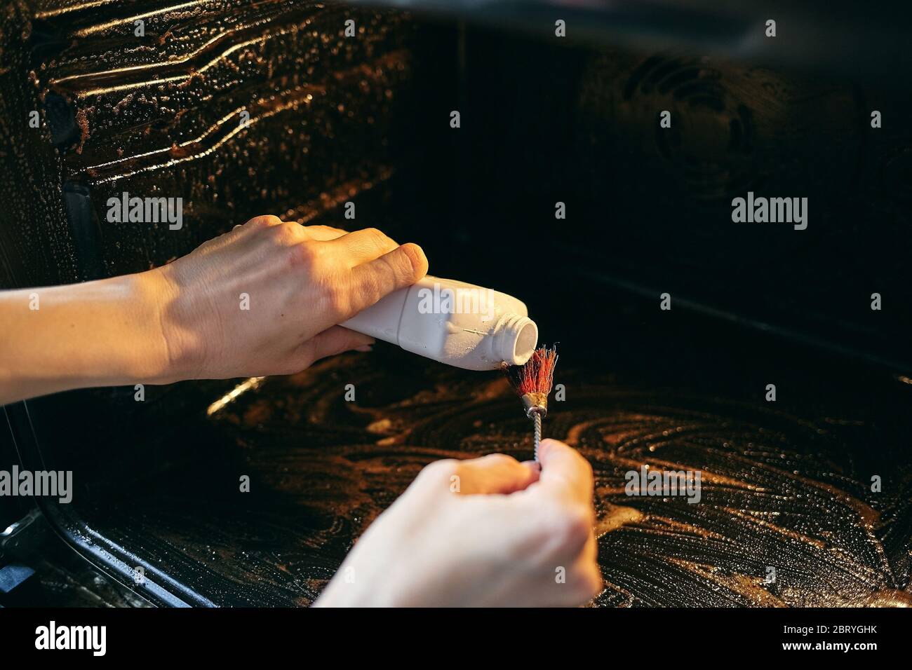 Un outil pour nettoyer le four et les cuisinières à gaz. Une femme nettoie  le four de la graisse et de la pollution Photo Stock - Alamy