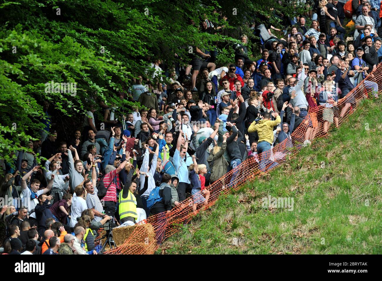 Le fromage qui descend la colline de Cooper, Brockworth près de Gloucester la foule y prend une photo de la vague mexicaine de Mikal Ludlow Phot Banque D'Images