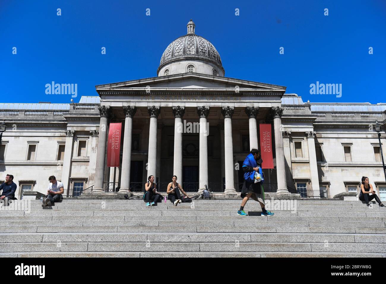 RETRANSMETTANT LA DATE DE MODIFICATION les gens sont assis sur les marches au soleil à Trafalgar Square, Londres, après l'introduction de mesures pour mettre le pays hors de l'isolement. Banque D'Images