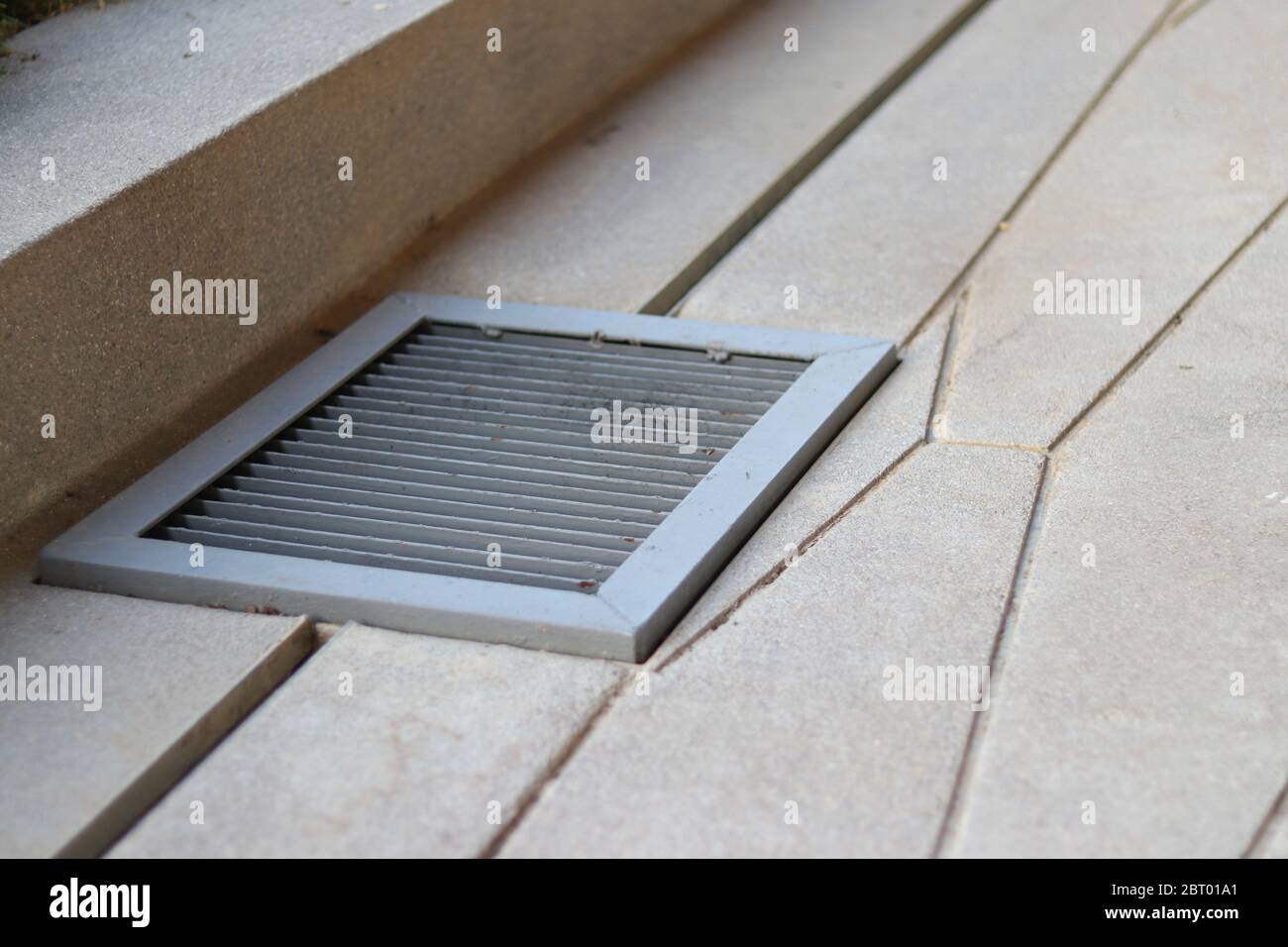 Couvercle d'évacuation gris sur le sol. Couvercle d'orifice d'homme en fer gris avec grille. Banque D'Images