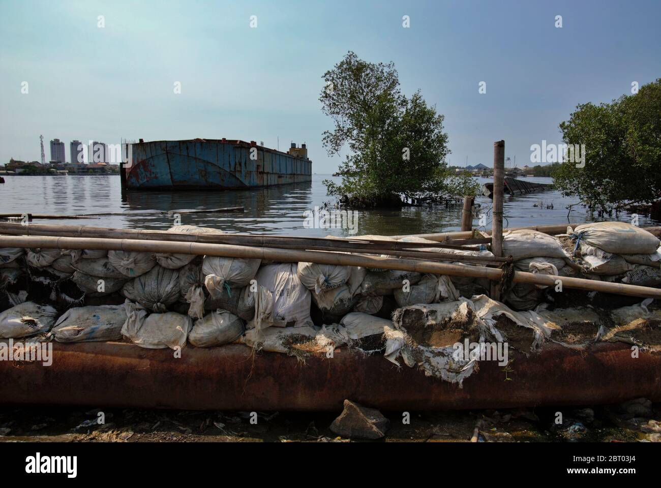Une barge offshore flottant près d'une structure de défense côtière dans le village de Muara Baru, au nord de Jakarta, Jakarta, Indonésie. Photo d'archive. Banque D'Images