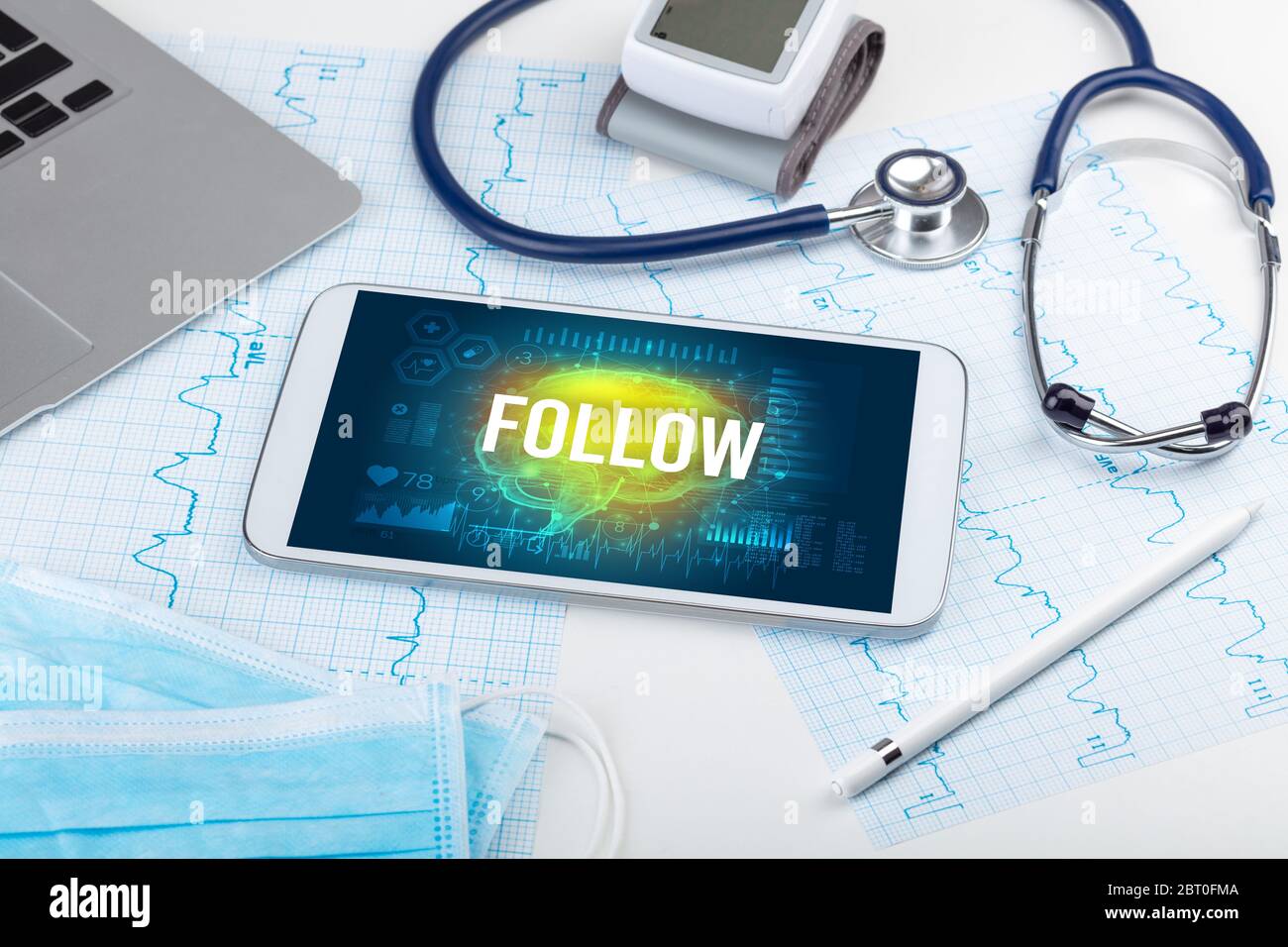 Tablette pc et outils médicaux avec inscription « FOLLOW », concept de distanciation sociale Banque D'Images