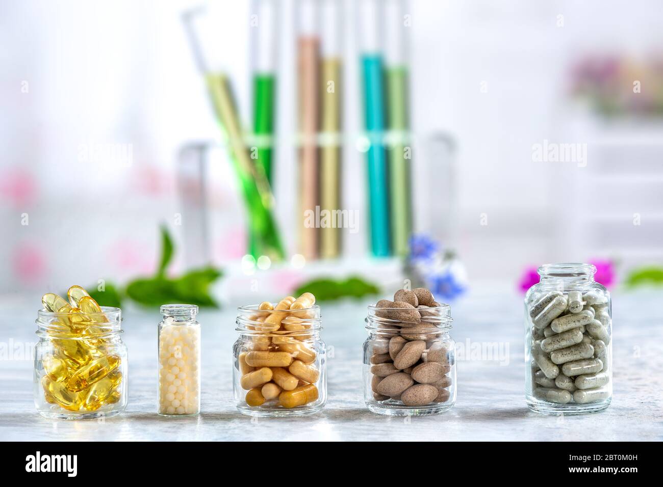 Concept de phytothérapie et compléments alimentaires. Phytothérapie comprimés secs avec des herbes naturelles sur fond de couleur légèrement. Banque D'Images