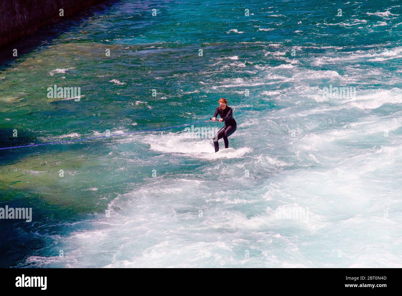 Surf sur les vagues rapides créées lorsque les portes de la sluice sont ouvertes sur la rivière Aarau dans le centre-ville de Thun, canton de Berne, Suisse. Banque D'Images