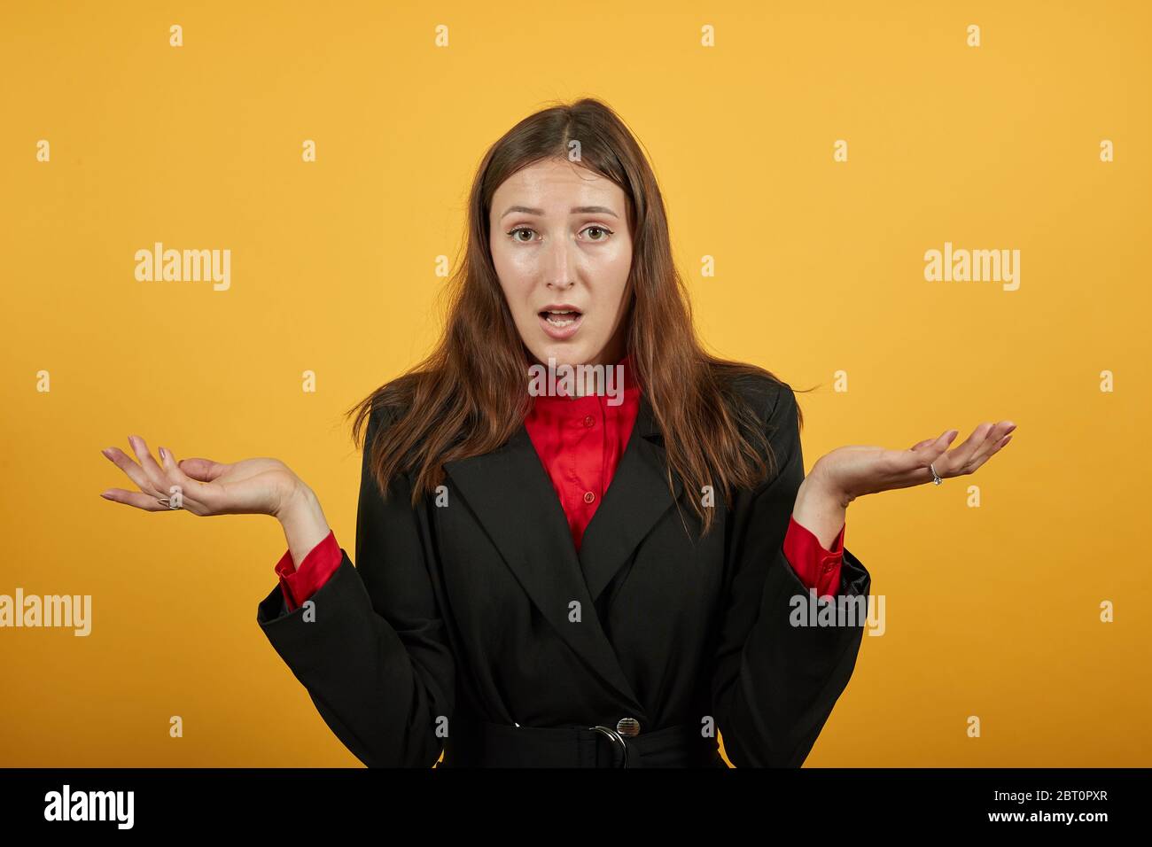 La femelle confuse tient les mains larges, les paumes tournées vers le haut. Des gens choqués qui sont bouleversés Banque D'Images