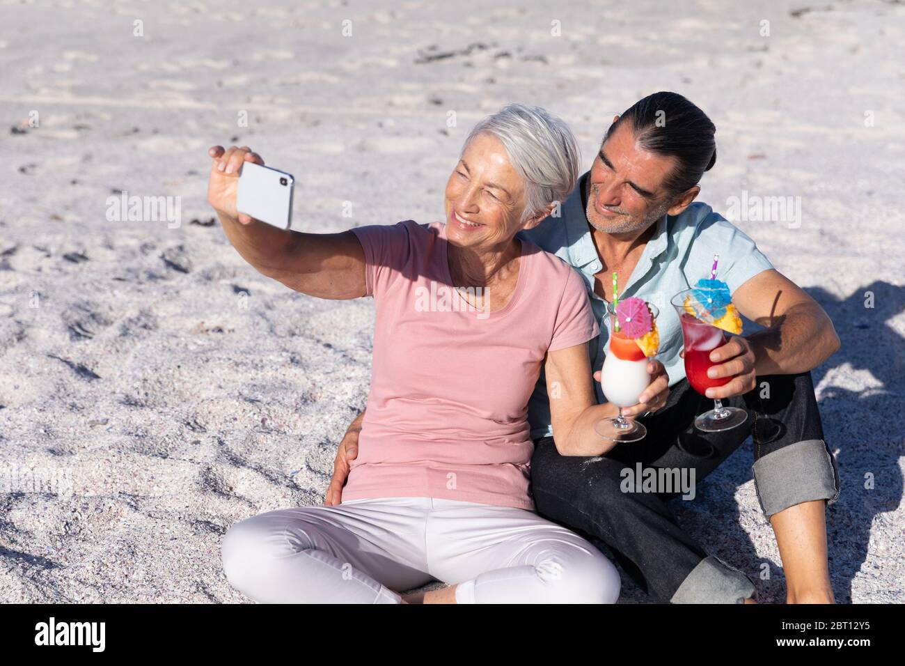 Couple caucasien senior prenant un selfie à la plage. Banque D'Images