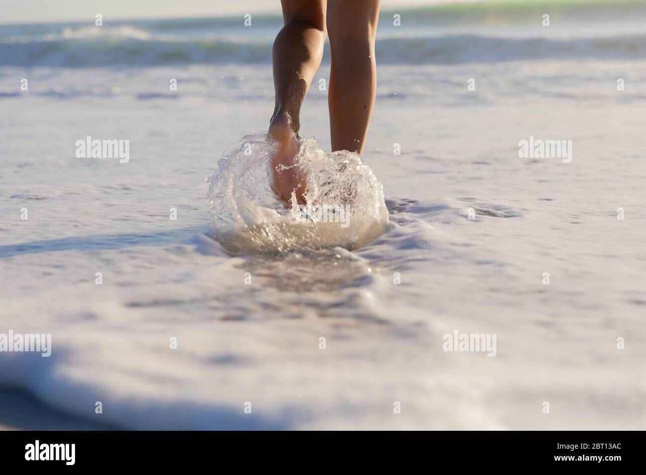 Femme caucasienne marchant vers la mer à la plage Banque D'Images