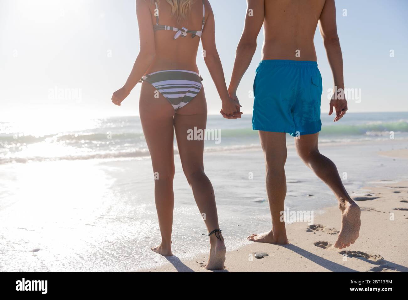 Couple caucasien debout dans l'eau à la plage. Banque D'Images