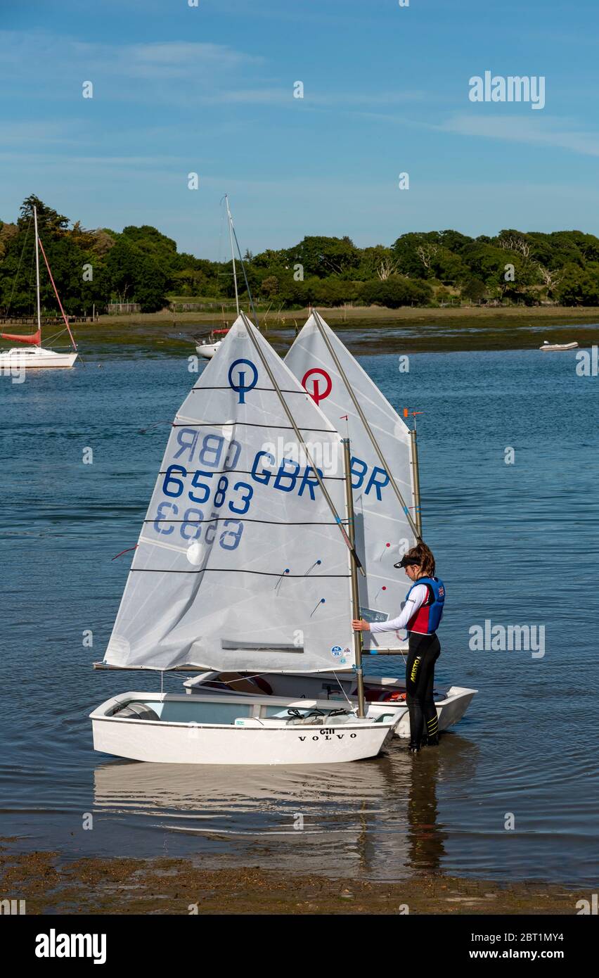 Lymington, Hampshire, Angleterre, Royaume-Uni. Mai 2020. Jeune garçon et fille apprenant à manipuler leurs voiliers Optomistes sur la rivière Lymington dans la Nouvelle forêt, champ Banque D'Images