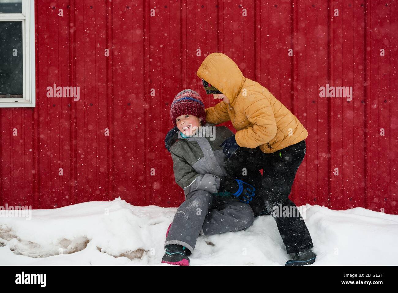 Deux enfants jouant dans la neige à l'extérieur d'une maison, USA Banque D'Images