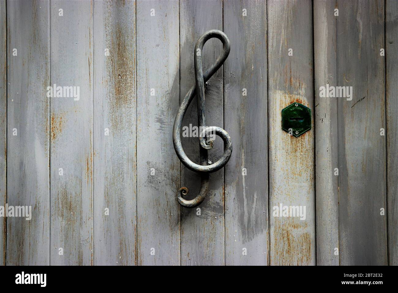 Poignée de porte en forme de clef triple sur une porte en bois Banque D'Images