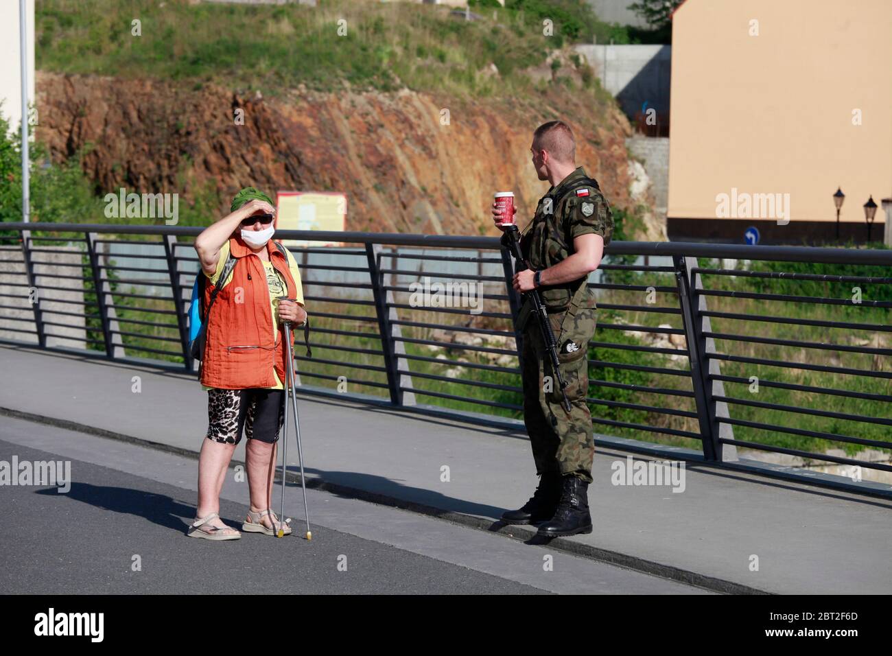 ein mit Maschinengehr bewaffneter polnischer Grenzschützer unterhält sich mit einer Frau an der Altstadtbrücke in Zgorzelec am 22.5.2020 Banque D'Images