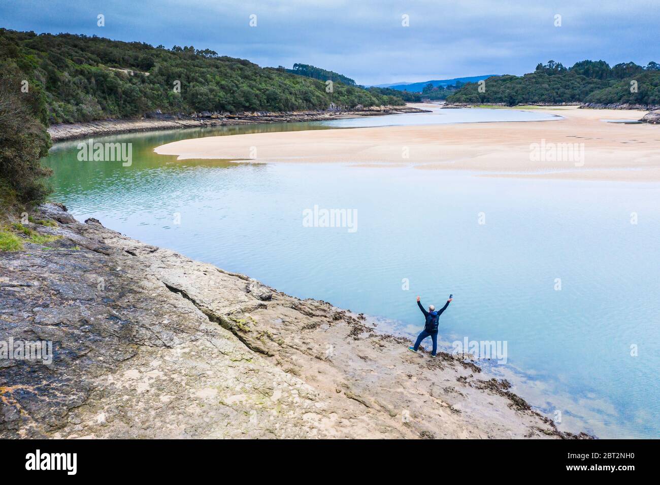 Homme, rivière et sédiments sablonneux à marée basse près de la mer. Banque D'Images