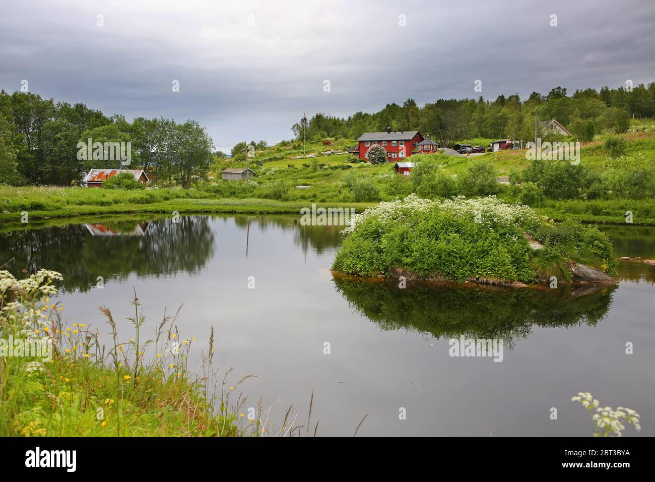 Magnifique paysage avec bord d'eau, avec un village, église et montagnes, Saltspraumen, municipalité de Bodo, comté de Nordland, Norvège. Banque D'Images