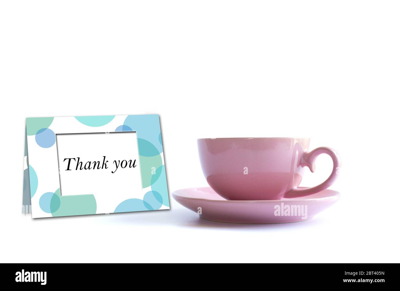 Tasse de thé en porcelaine rose avec carte de remerciement sur fond blanc. Carte, affiche, maquette. Célébration, anniversaire, concept d'anniversaire. Banque D'Images