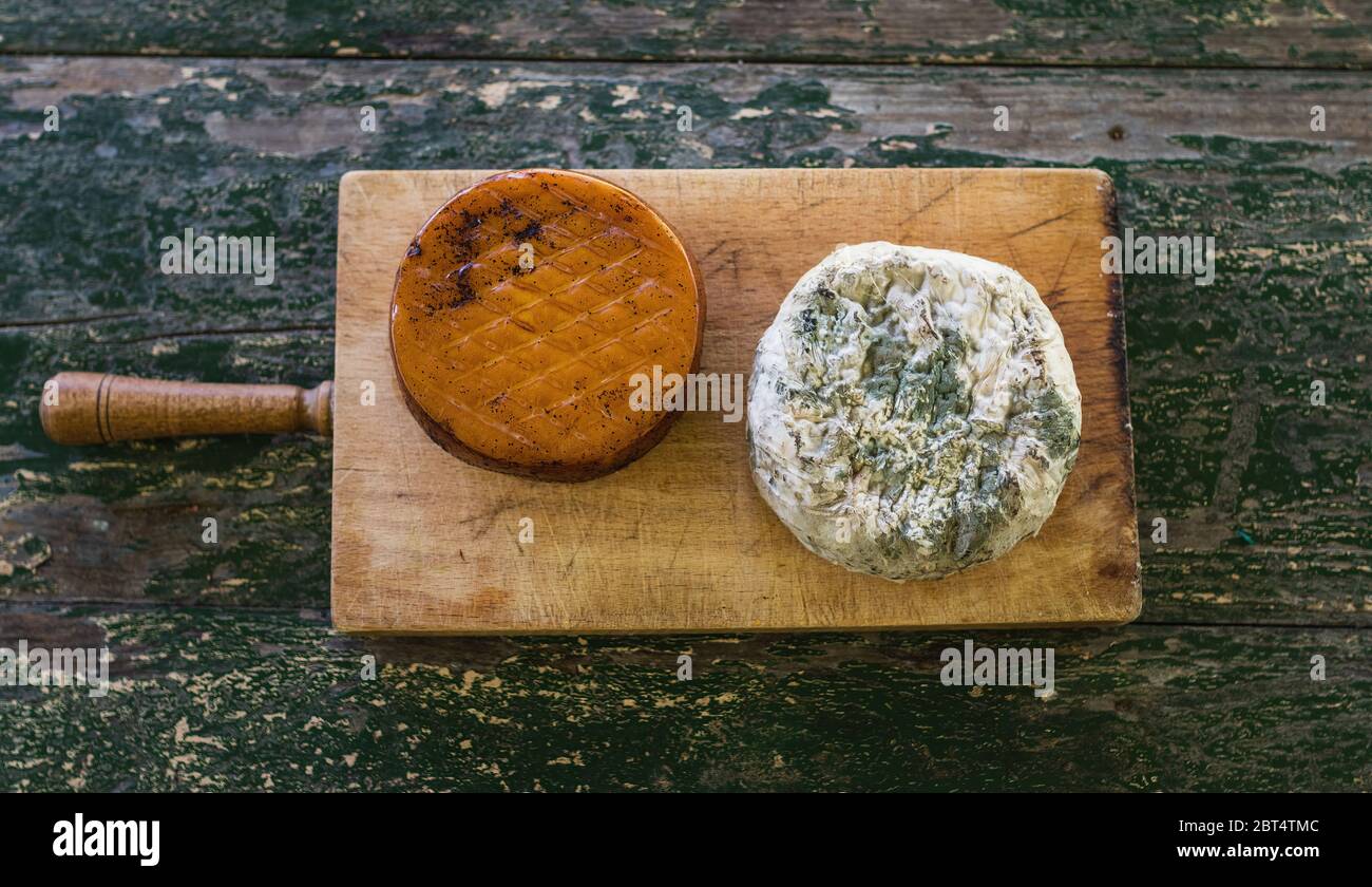 Vue de dessus de deux fromages sur une table rustique en bois. Fromage fumé et bleu moldy. Banque D'Images