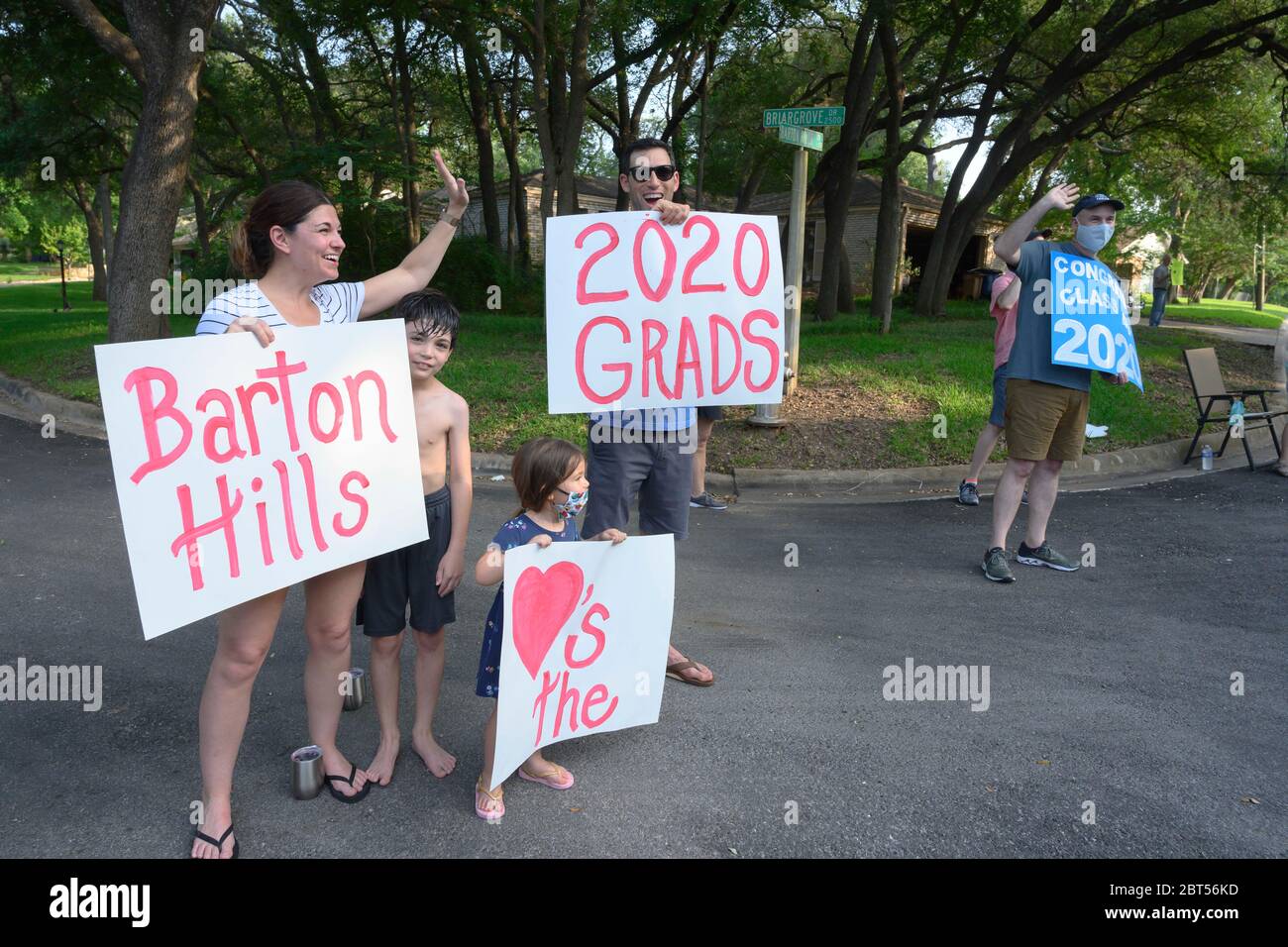Les résidents applaudissent tandis que les diplômés du secondaire défilent dans leur quartier d'Austin, au Texas, à la suite de la pandémie COVID-19 qui a raccourci l'année scolaire et forcé l'annulation des cérémonies traditionnelles de commencement en personne. Banque D'Images