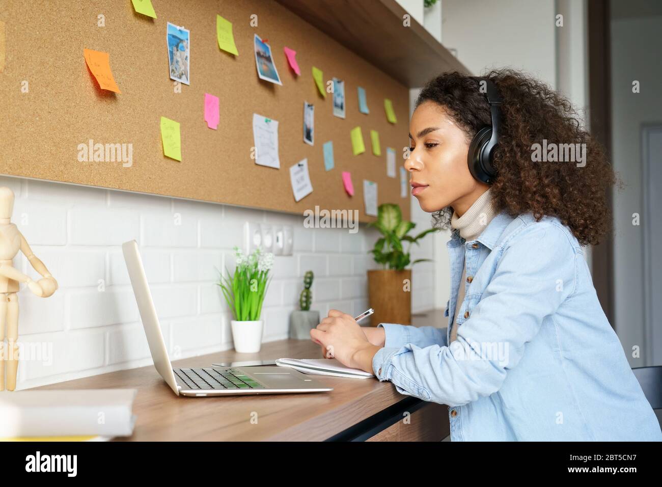 Fille africaine étudiant porter des écouteurs à distance apprentissage regarder le webinaire vidéo. Banque D'Images