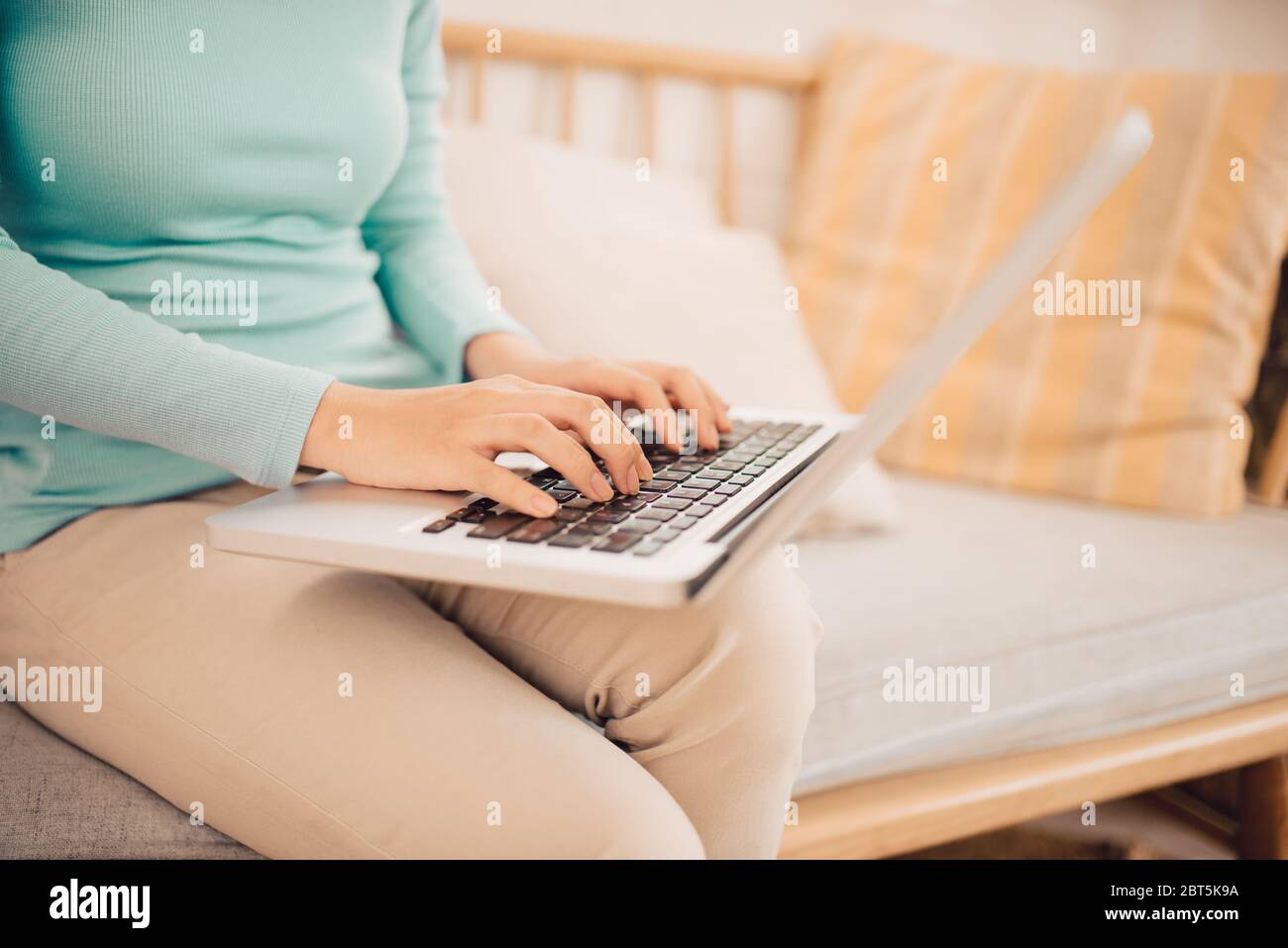 Young Asian woman working on laptop at home. Banque D'Images