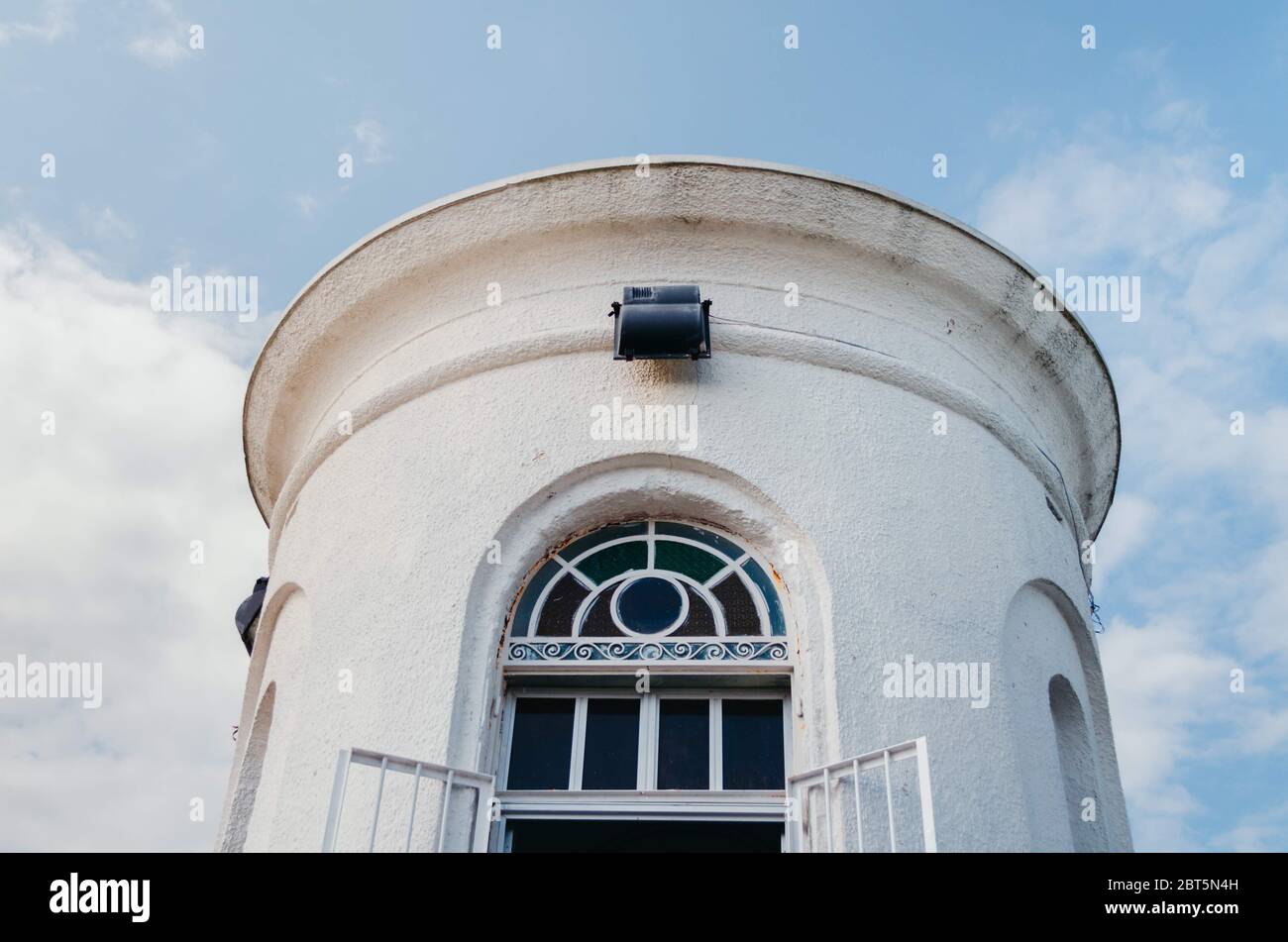 Tour de colline de San Antonio peinte en blanc avec fenêtre colorée et ciel bleu nuageux. Banque D'Images