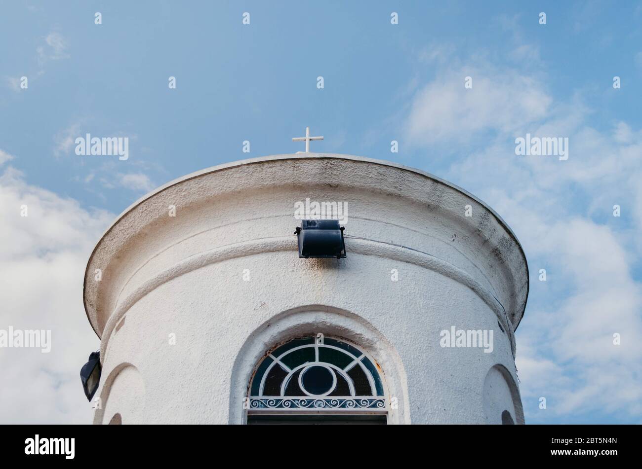 Tour de colline de San Antonio peinte en blanc avec fenêtre colorée et ciel bleu nuageux. Banque D'Images