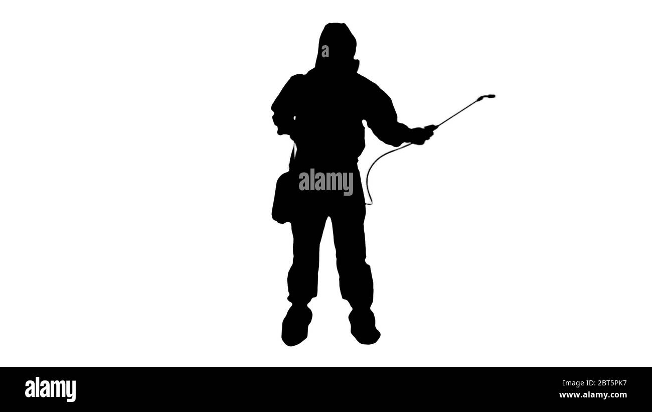 Silhouette Man portant un équipement de protection individuelle (epi) NBC en vaporisant de l'eau désinfectante pour éliminer le coronavirus Covid-19. Banque D'Images