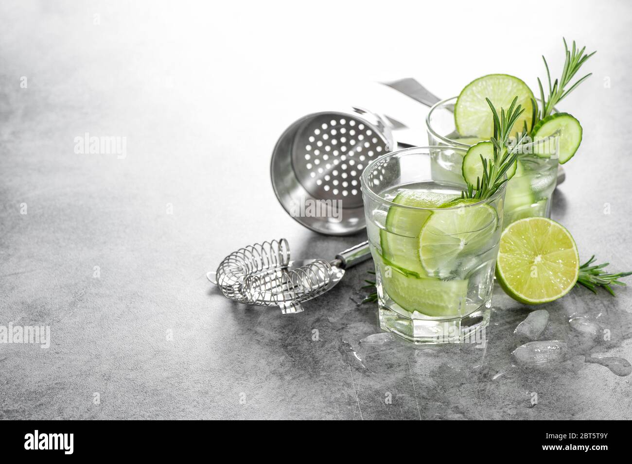 Boisson fraîche et froide avec concombre, citron vert, romarin, glace. Accessoires de barre Banque D'Images