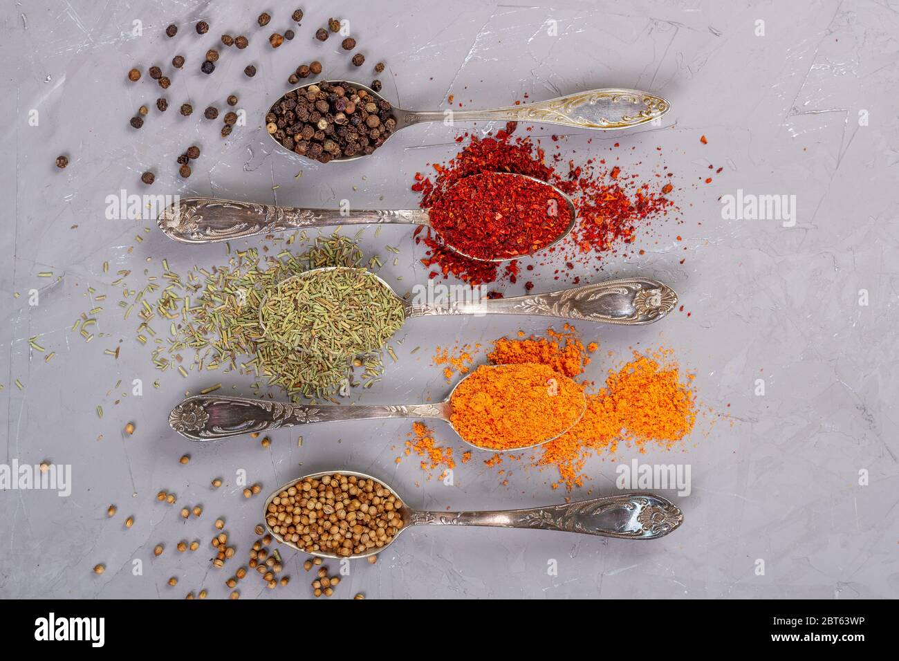 Séchez les épices de différentes couleurs dans des cuillères à café. Vue de dessus Banque D'Images