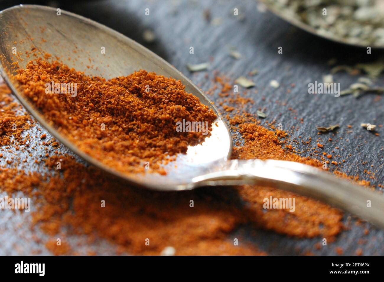 Une cuillère à café de poivre de Cayenne ou de paprika sur fond d'ardoise. Ingrédients crus pour la cuisson Banque D'Images