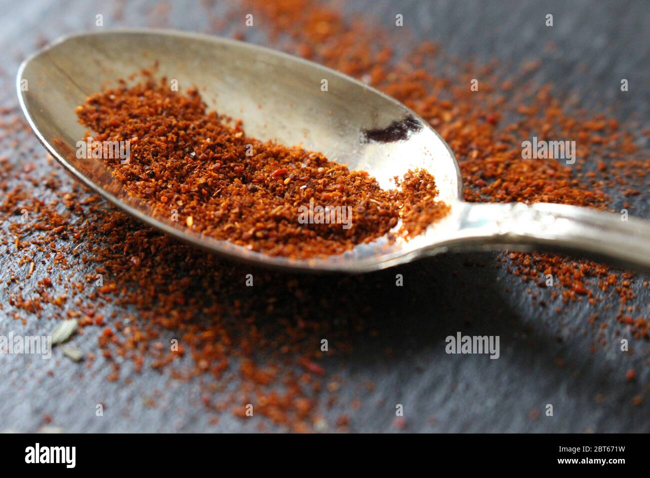 Une cuillère à café de poivre de Cayenne ou de paprika sur fond d'ardoise. Ingrédients crus pour la cuisson Banque D'Images