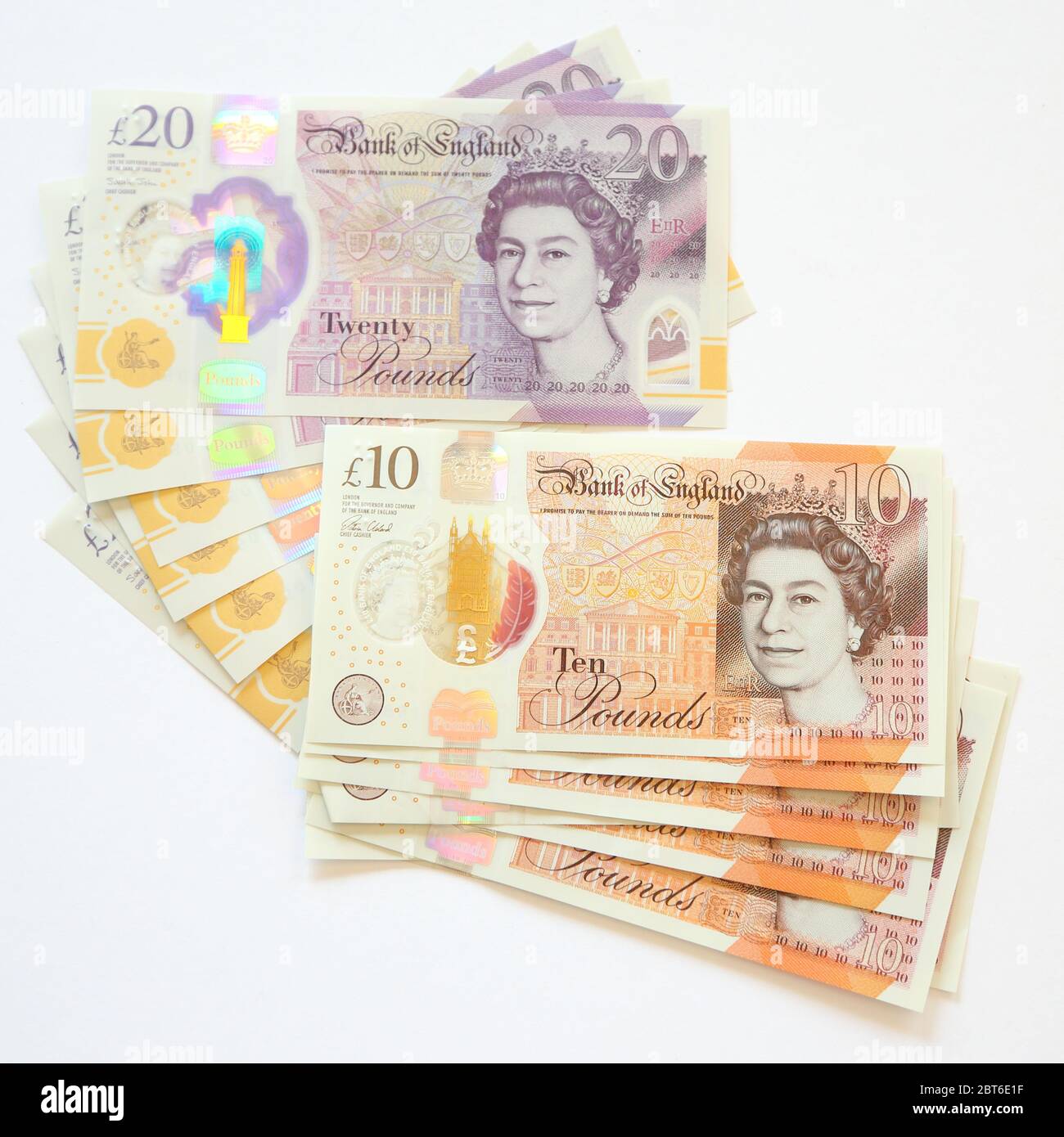 Dix billets de 10 et vingt-cinq livres sterling 20 sur fond blanc Banque D'Images