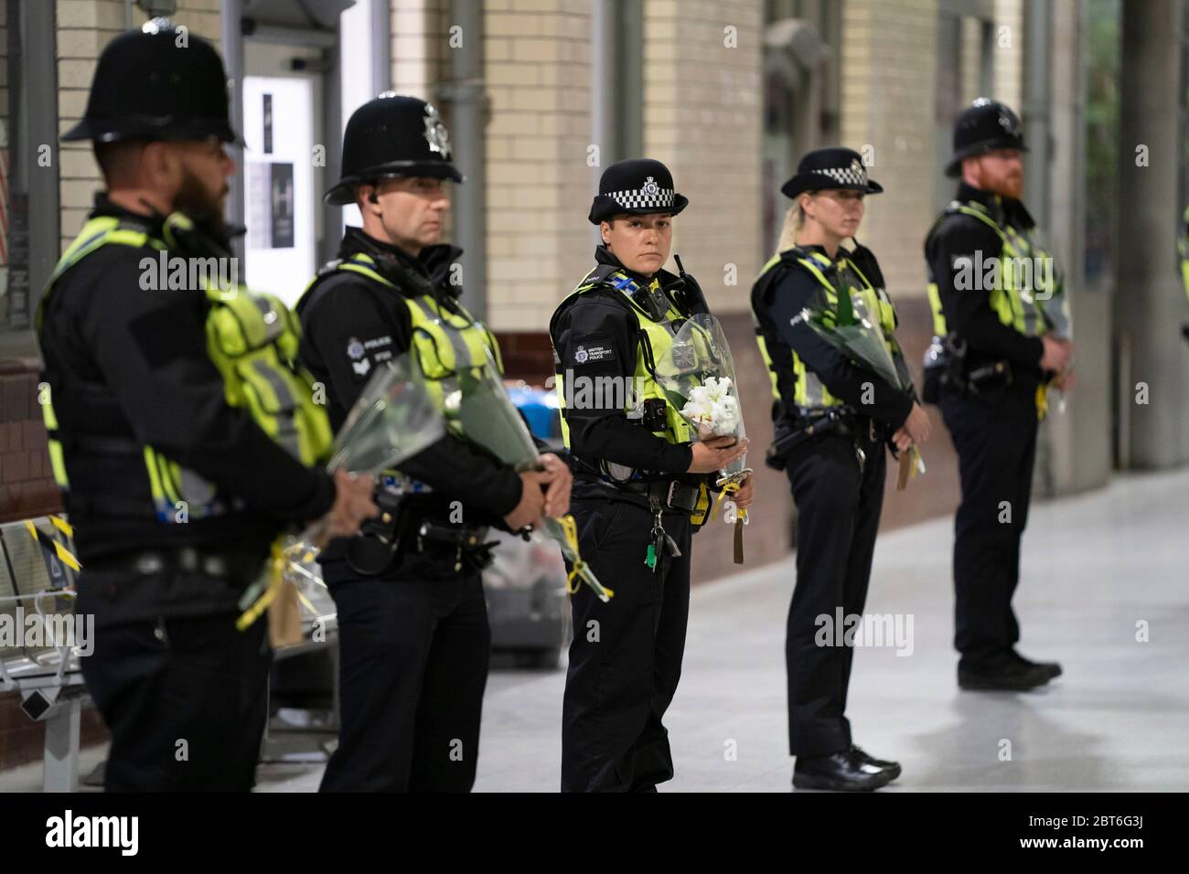 Manchester, Royaume-Uni. 22 mai 2020. Les policiers tiennent des grappes de fleurs en ligne à la gare de Manchester Victoria pour marquer le 3e anniversaire de la bombe Manchester Arena, Manchester, Royaume-Uni. Crédit : Jon Super/Alay Live News. Banque D'Images
