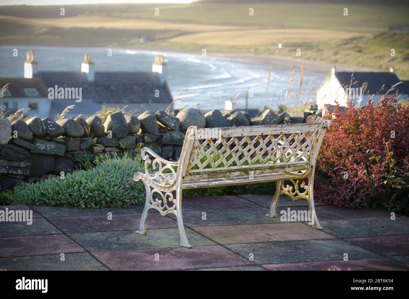 Banc en fonte très orné surplombant le village pittoresque de Port Logan, Mull de Galloway Banque D'Images