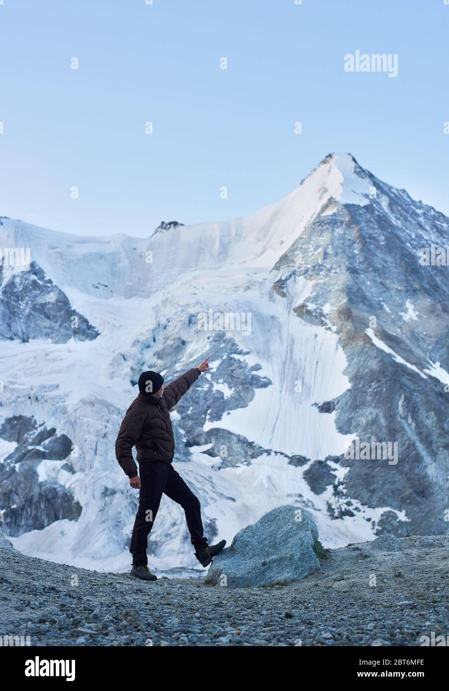 Vue latérale instantané d'un touriste pointant sur l'une des plus belles montagnes des Alpes suisses - Ober Gabelhorn, dont un côté est couvert de neige. Nature avec vue imprenable. Tourisme sportif dans les Alpes. Banque D'Images