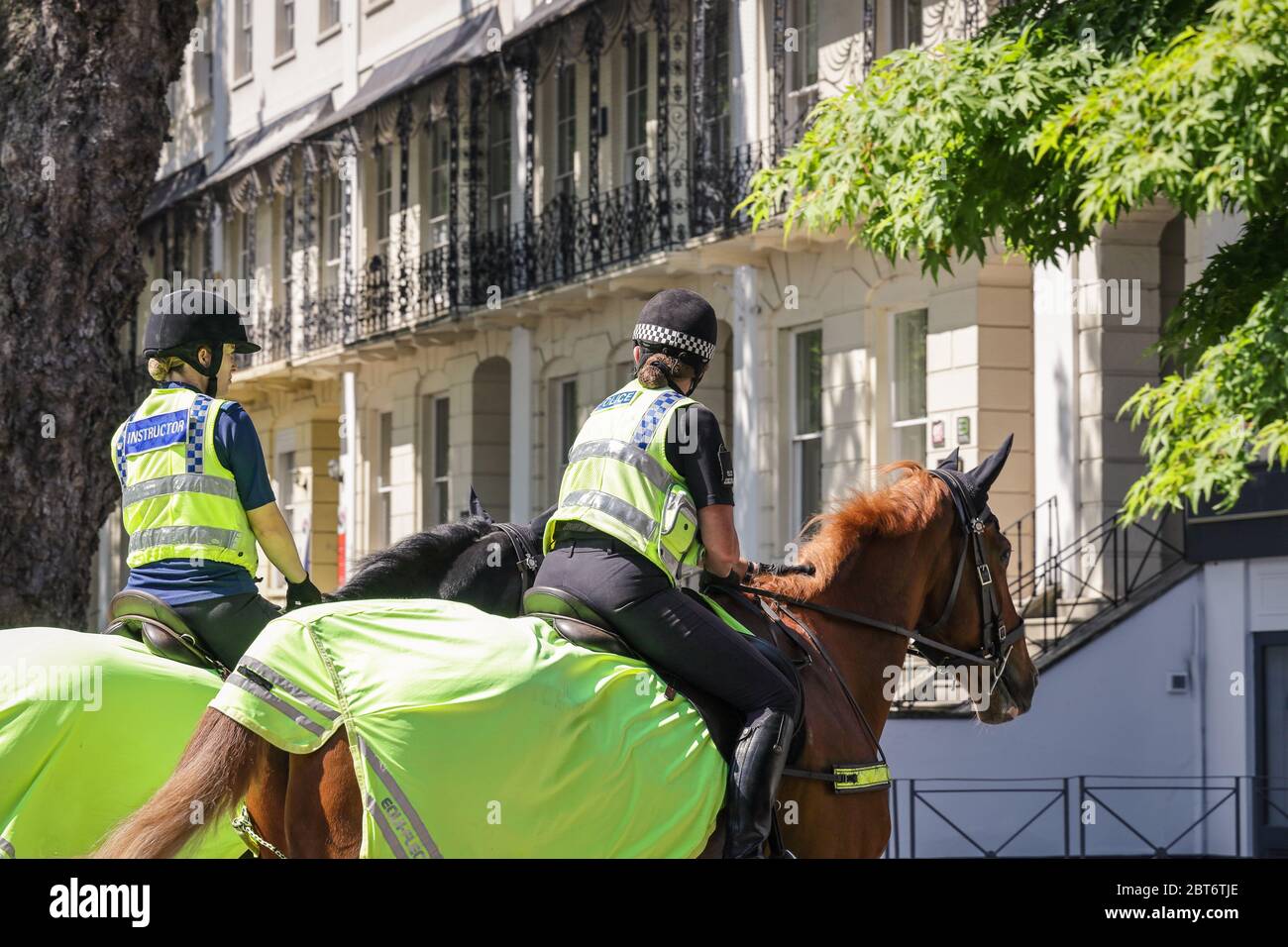 Deux policiers féminins patrouillent à cheval dans le centre-ville de Cheltenham pendant la quarantaine de l'éclosion du coronavirus, en mai 2020 Banque D'Images