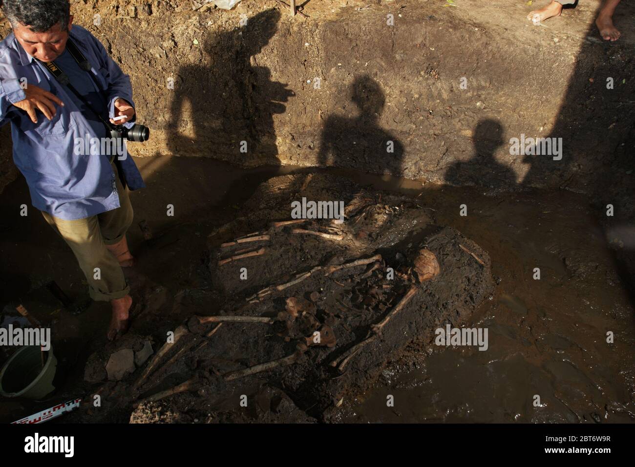 Un membre de l'équipe d'excavation et de recherche du Centre archéologique national indonésien (Arkenas) se prépare à prendre des photos scientifiques de squelettes humains probablement datés de la période protohistorique indonésienne, sur un site d'excavation inondé à Karawang, à Java Ouest, en Indonésie. Image d'archivage (2010). Photo: Reynold Sumayku Banque D'Images