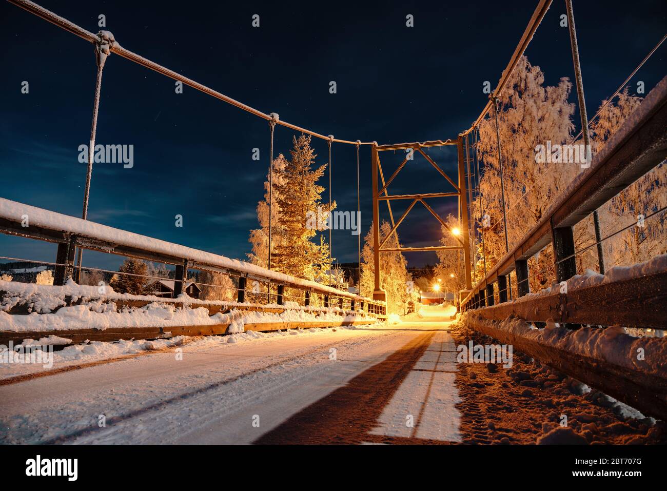 Vue nocturne sur la Lune au-dessus du pont métallique du Près-restaient dans la campagne suédoise, il est éclairé par des lumières, froid hiver ciel bleu avec des étoiles et thi Banque D'Images