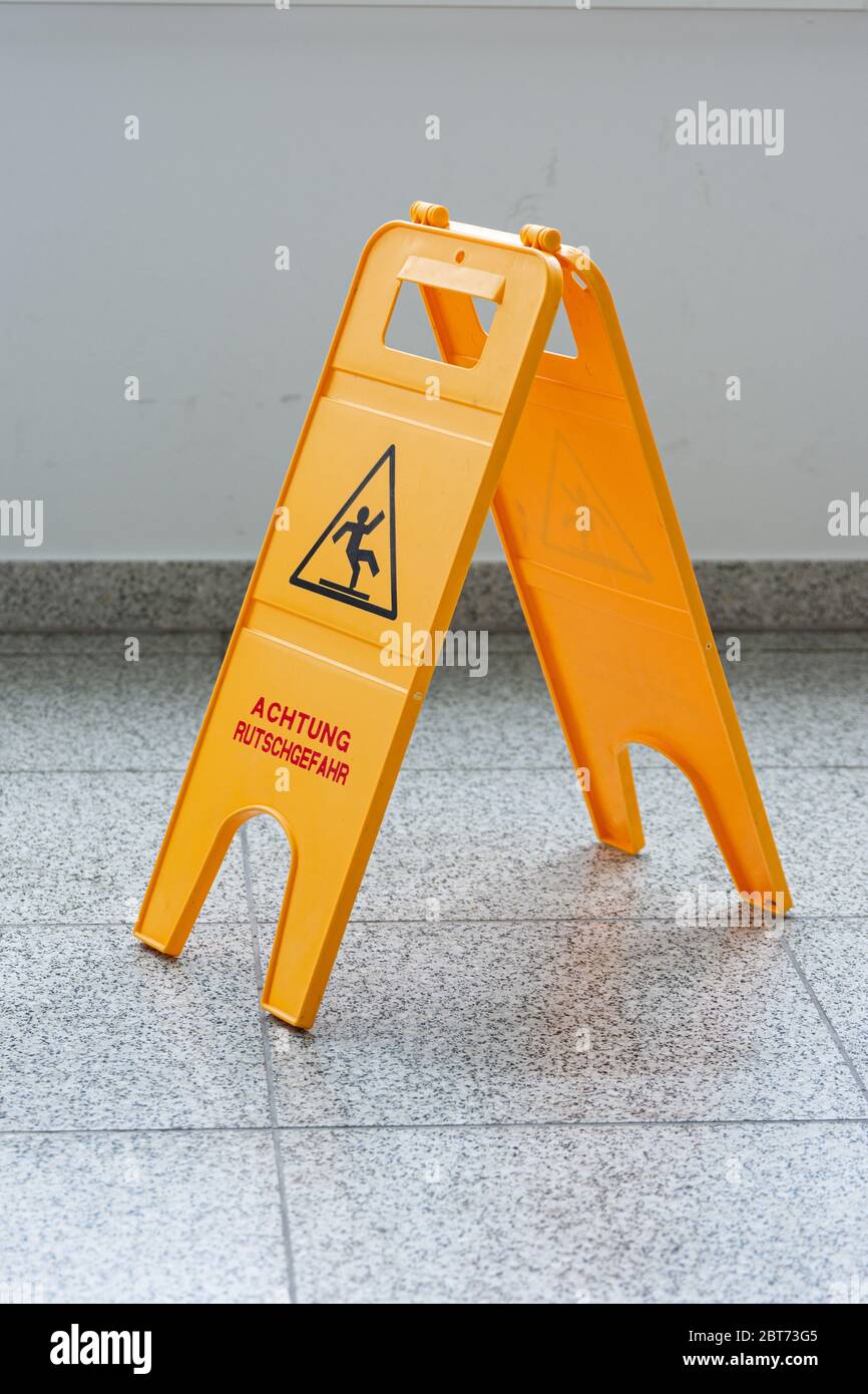 Attention sol mouillé ou nettoyage en cours. Un panneau jaune signale un danger. Banque D'Images