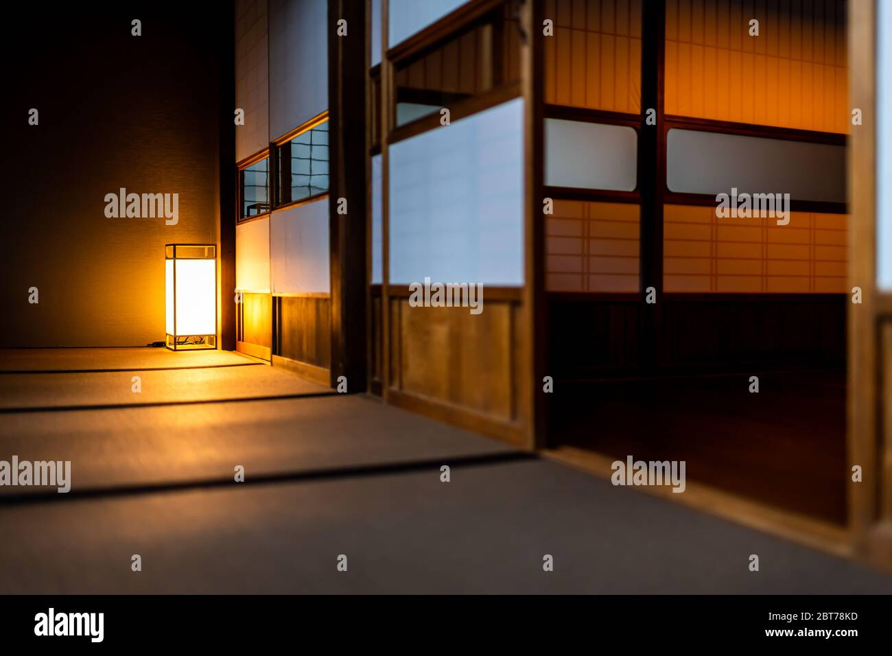 Chambre japonaise traditionnelle vue à angle bas dans la maison ou ryokan avec shoji ouvert portes coulissantes en papier tatami sol et lampe illuminée la nuit sans Banque D'Images