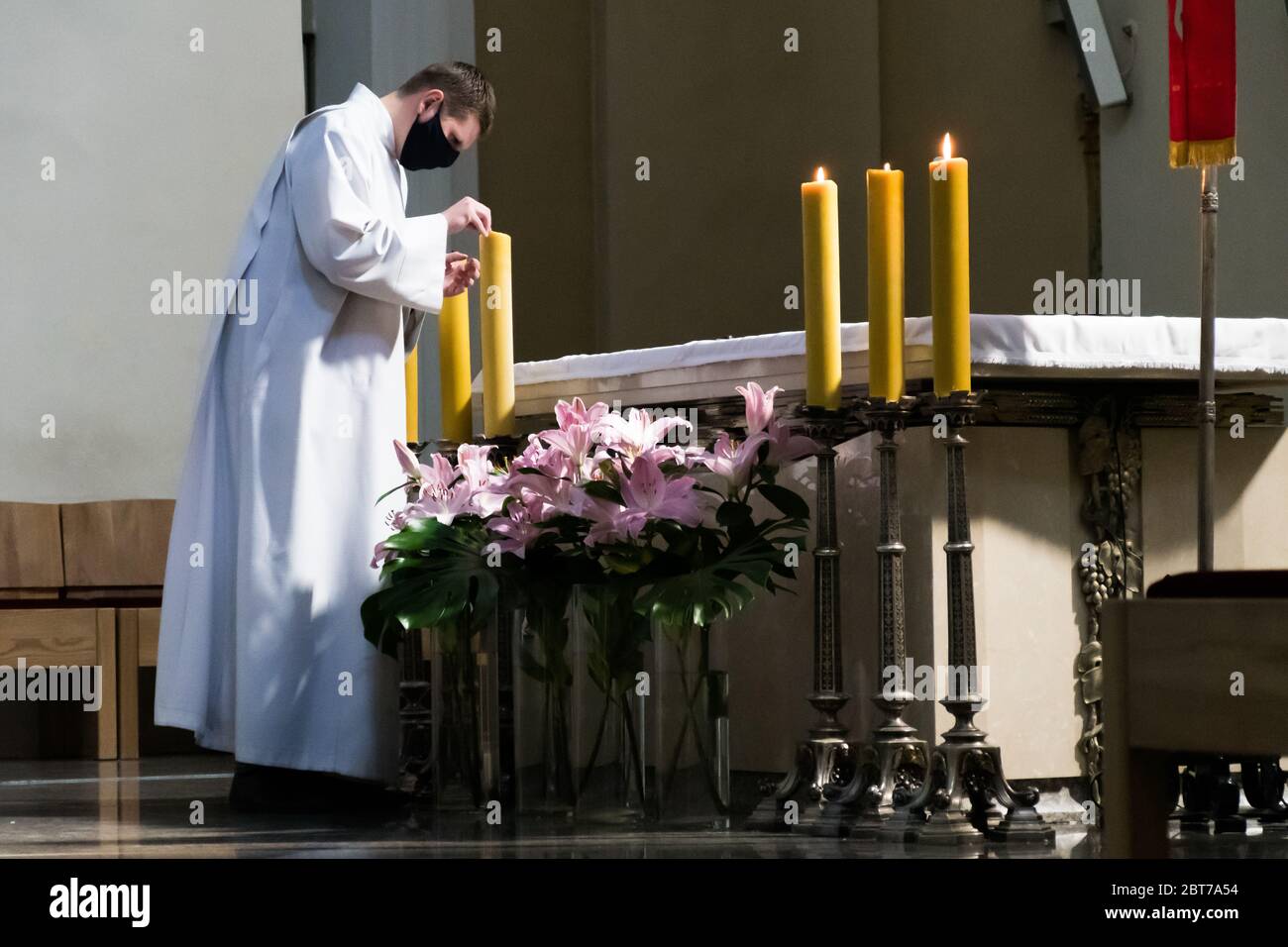 Prêtre avec masque facial protecteur dans une église pendant l'urgence de Covid ou coronavirus, rouvrant l'église Banque D'Images