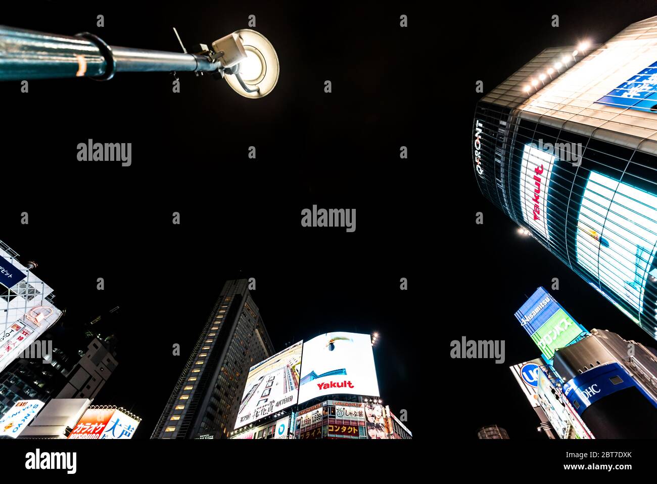 Shibuya, Japon - 1er avril 2019 : célèbre traversée du centre-ville de Tokyo avec panneaux d'affichage au néon, lumières, vue à angle bas, paysage urbain et publicitaires Banque D'Images