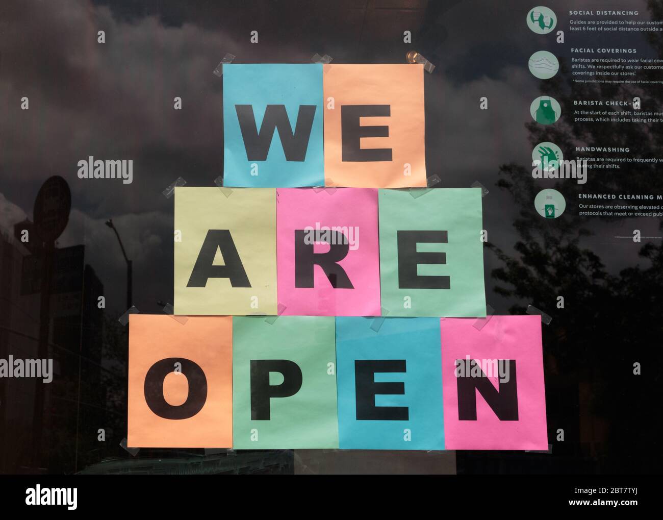 Coloré, nous sommes un panneau ouvert affiché dans un café Starbucks pour informer le public qu'il a rouvert pendant la pandémie du coronavirus ou du covid-19 Banque D'Images